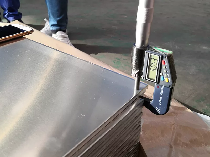 Digital micrometer measuring the thickness of a 5052 aluminum sheet